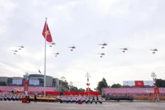 人民空军直升机编队悬挂党旗与国旗飞越河内上空。图自越通社