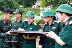 顺化市军事指挥部副政委河文爱大校（左三）在地图上确定烈士安葬位置。图自越通社