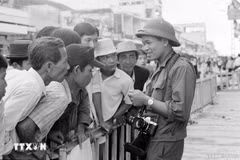 越通社记者许检在西贡会见群众，报道并拍摄1975年历史性胡志明战役的胜利，完全解放南方，实现国家统一。图自越通社