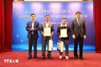 越南科学技术翰林院副院长周黄河向烈士家属授予DNA鉴定结果。图自越通社