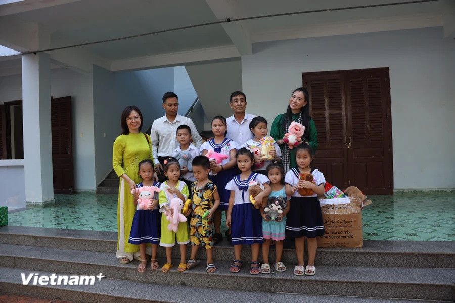 岛上儿童们跟前往长沙群岛工作的代表团合影。图自越通社