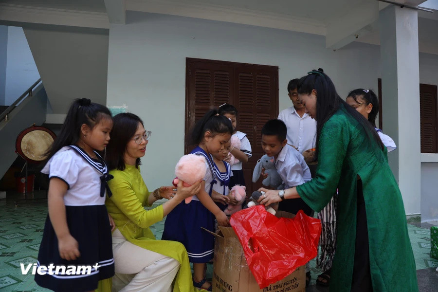 赴长沙群岛工作的代表团向岛上儿童们赠送礼物。图自越通社