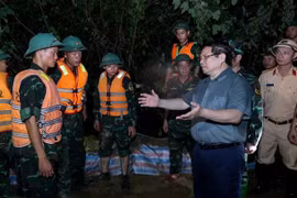 范明政总理慰问激励正在加固堤防、防止洪水漫溢，确保右桥堤段安全的的抢险力量。图自越通社
