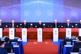 政府总理范明政在工程开工仪式上与工人们亲切握手。图自越通社