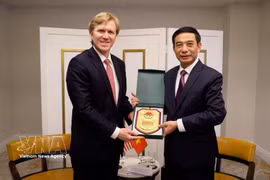 越南国防部部长潘文江向美国战争部第一副部长科尔比赠送礼品。图片来源：越通社