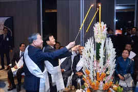 越共中央总书记苏林同通伦·西苏里共同进行老挝传统拴线仪式。 图片来源：越通社