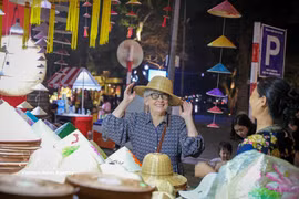 国际游客在2025年河内旅游礼品节上对越南传统产品爱不释手。图片来源：越通社