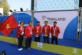 越南文化、体育与旅游部副部长黄道刚与代表团团长黎氏黄燕同夺得金银铜奖牌的3名运动员合影留念。图片来源：越通社