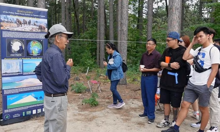邓忠福博士（左）正在介绍平希沙丘的历史由来。图自越通社