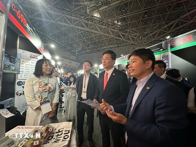 代表们参观越南展位的产品。图自越通社