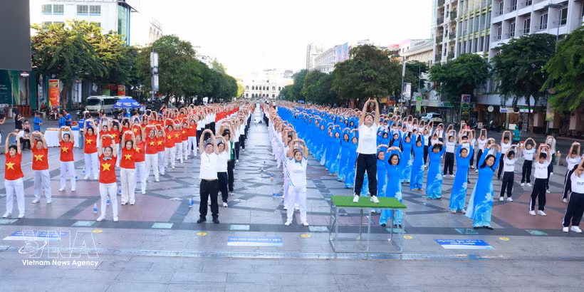 医务人员与民众同演健身操，向社区传递健康生活理念。图自越通社