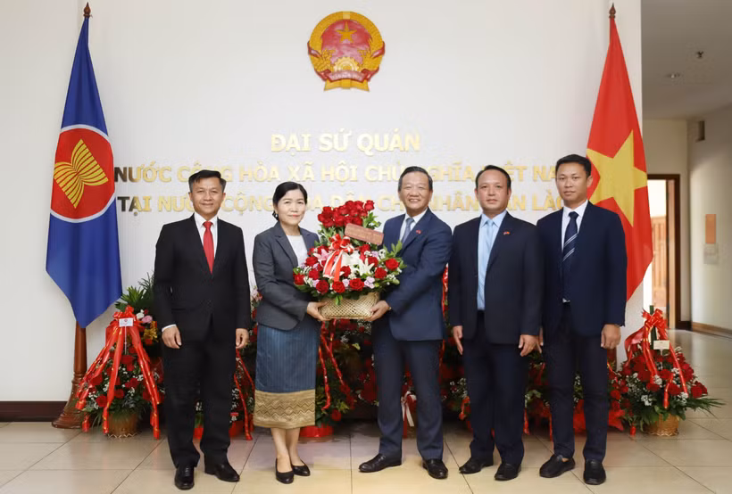 老挝财政部代表与越老合作委员会代表赠送献花，祝贺越南国庆80周年。图自越通社