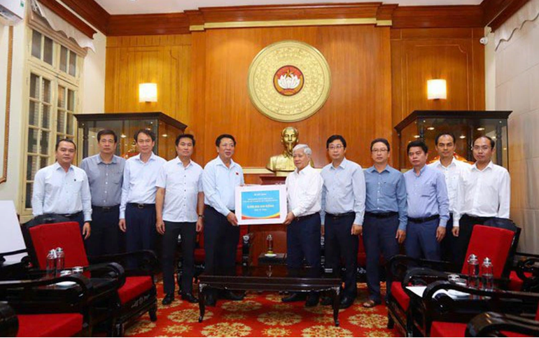 建设部领导向越南祖国阵线中央委员会主席杜文战移交捐款。图自越南妇女报
