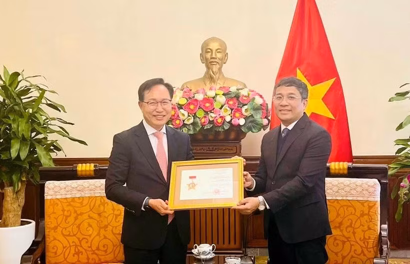 越南外交部常务副部长阮明宇向三星越南公司总经理崔裕浩授予“致力于越南外交事业”纪念章。图自越通社