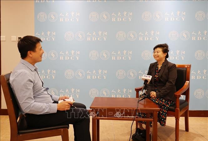 中国人民大学重阳金融研究院研究员刘英（右）接受越通社记者的采访。图自越通社