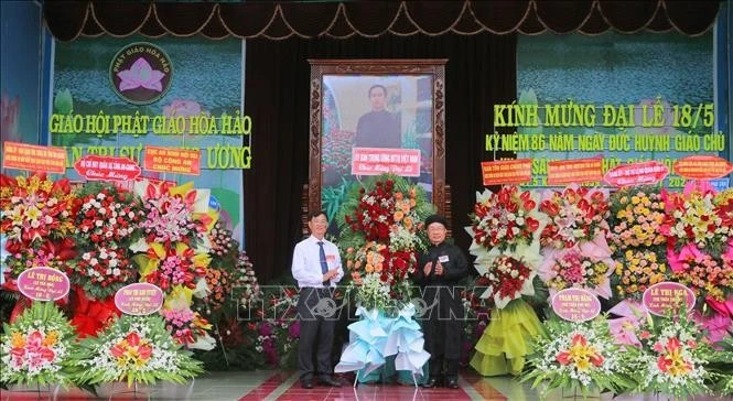 安江省越南祖国阵线委员会副主席裴文赠（左）送花祝贺和好佛教创立86周年。图自越通社