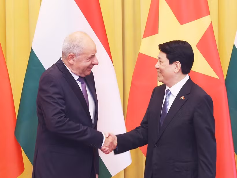 越南国家主席梁强与匈牙利总统舒尤克·道马什亲切握手。图自越通社