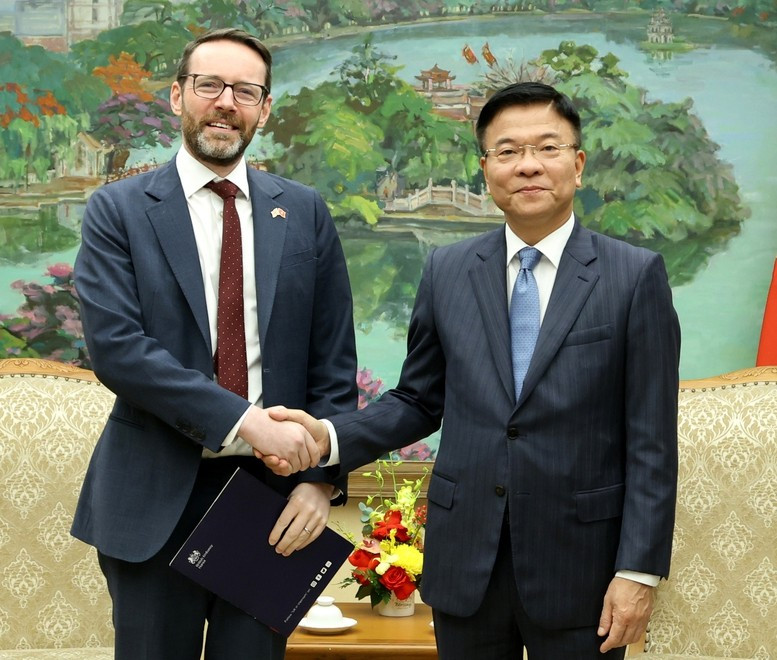 越南政府副总理黎成龙与英国驻越南特命全权大使伊恩·弗鲁亲切握手。图自越通社