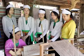 富寿省新山艺人们正向年轻一代传递热情，共同保护和弘扬芒族的传统土锦纺织技艺。图自越通社