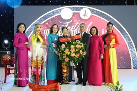 越南驻德国大使阮得成向欧洲越南女企业家协会主席郑氏未赠送鲜花表示祝贺。图自越通社