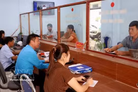 劳寨乡公共行政服务中心工作人员指导群众办理行政手续。图自越通社