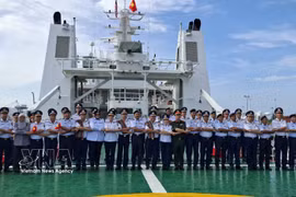 越南海警代表与马来西亚海事执法局（MMEA）彭亨州代表在CSB 8005号舰上，按东盟传统进行合影留念。图自越通社