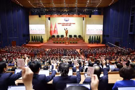 在越南共产党第十四次全国代表大会召开闭幕会议上，与会代表表决通过大会决议。图自越通社