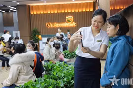 Vietcombank银行业务人员引导客户使用银行应用程序上的生物识别功能。图自《人民军队报》