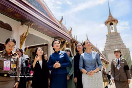 身着泰国传统服饰的吴芳璃夫人在塔纳农·参威拉军女夫人的陪同下，参观泰国大皇宫。图自越通社