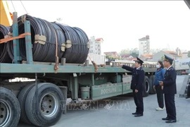 登站口岸海关干部检查进出口货物。图自越通社