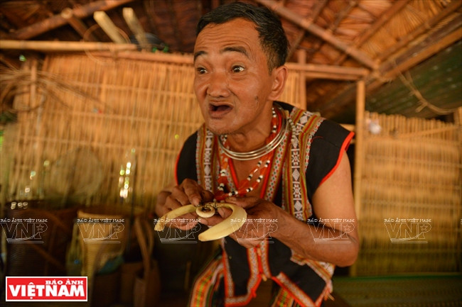 胡根老人向游客夸耀用野猪牙做的项圈。本报记者 清和 摄