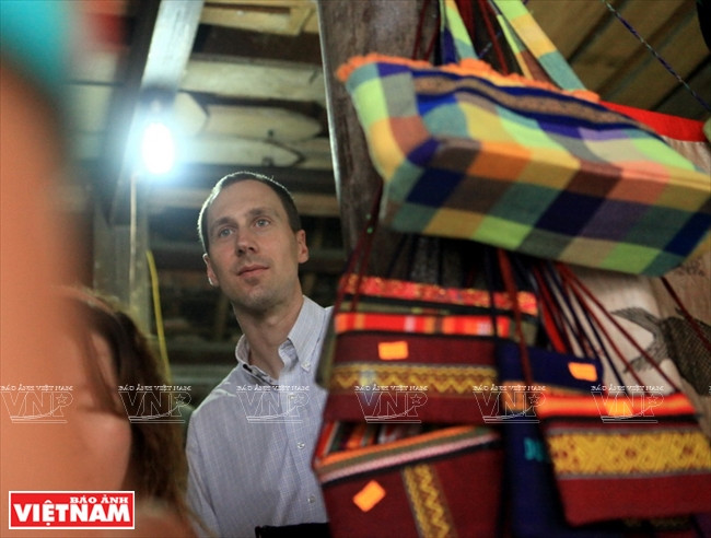美国游客Brian Bean 选购傣族土锦。图自越南画报