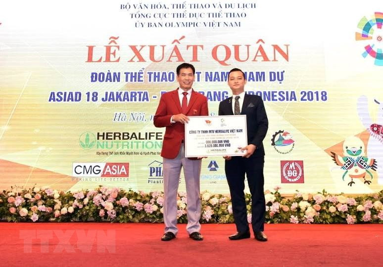 越南康宝莱公司总经理范祥辉向2018年第18届亚洲运动会越南体育代表团赠送赞助金。越通社记者 仲达 摄