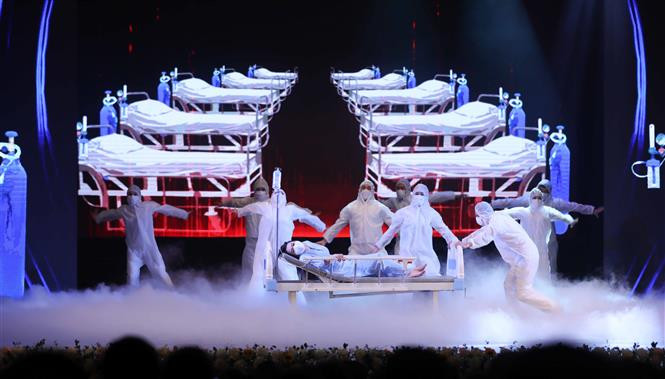 由人民电视频道和《人民报》举办题为‘2022年温暖春节’艺术表演活动上的舞蹈表演节目，再现医生们为新冠肺炎患者进行救治场景。图自越通社