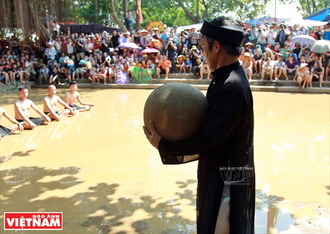 经精心挑选的一位老人抱着约重20公斤的木球带到比赛场地。图自越通社