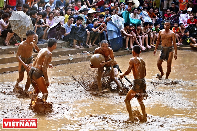 队员除了要拿着较重的泥球，还要在湿滑的泥水池走动。图自越通社