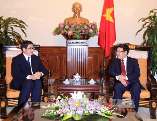  越共中央政治局委员、政府副总理兼外交部长范平明会见即将离任前来辞行拜会的新加坡驻越南大使伍德贤。（图片来源：越通社）