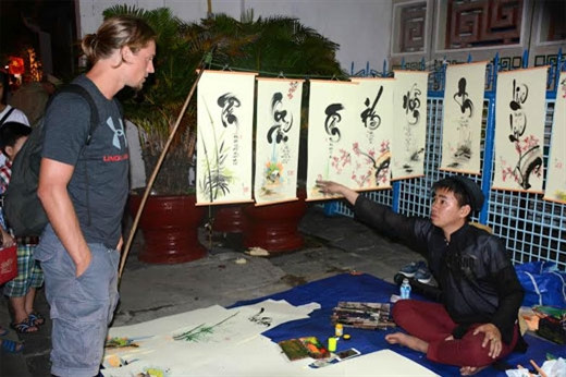 书法摊吸引住国际游客的眼球。（图片来源：人民军队报）