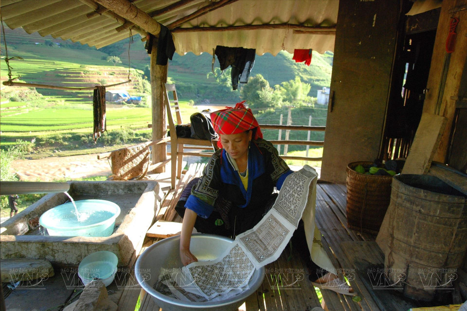 为了制作出不易褪色的靛蓝色布料，布料要经过多次染色。将布浸入靛蓝水中浸泡，然后在阳光下晾干，这一程序要重复几遍。图自 《越南画报》