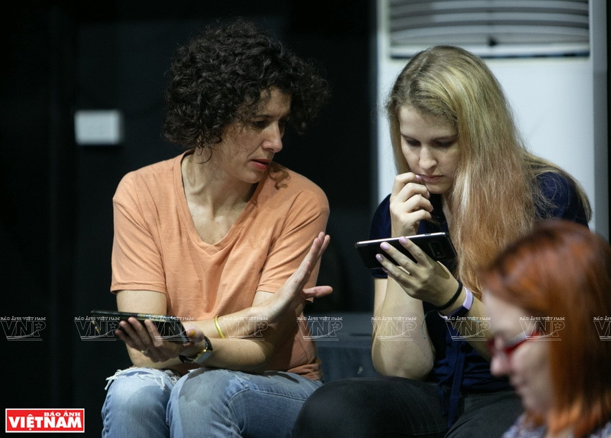 安妮与国际朋友了解越南文化艺术。图自越通社/越南画报