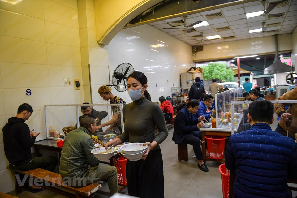 店里所有食客都要洗手消毒并保持安全距离。 图自越通社
