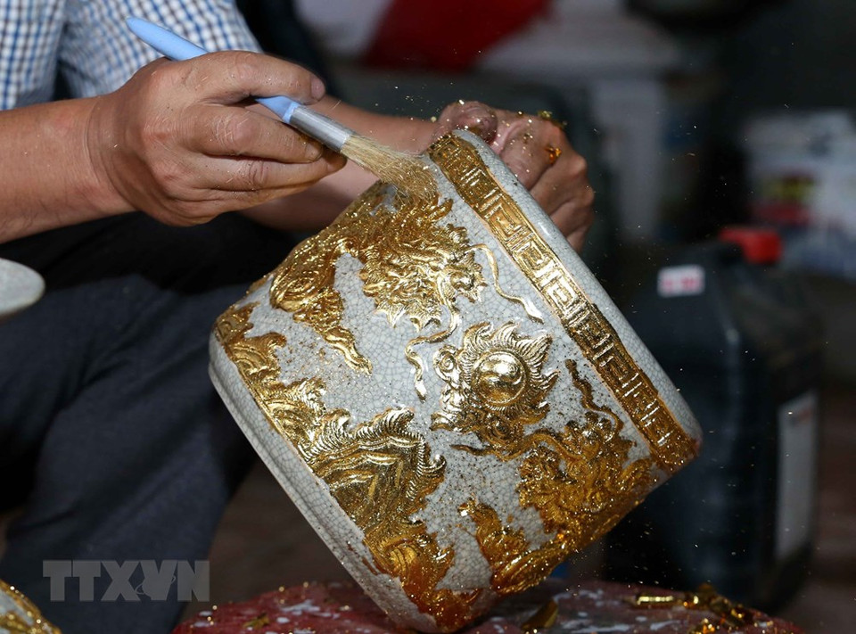 艺人在陶瓷作品上进行贴金箔。越通社记者 陈越 摄