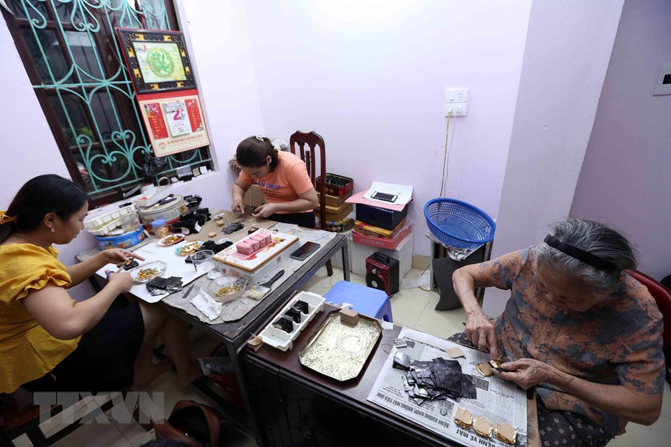 阮文钟艺人家庭参加制作金箔的不同工序。越通社记者 陈越 摄