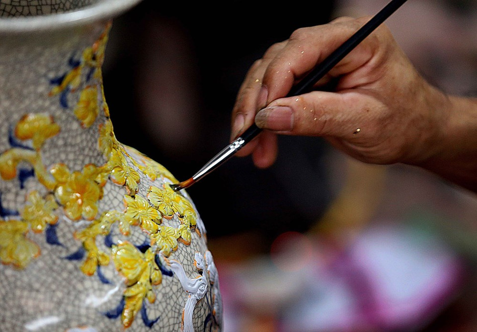 艺人在陶瓷作品上进行贴金箔。越通社记者 陈越 摄