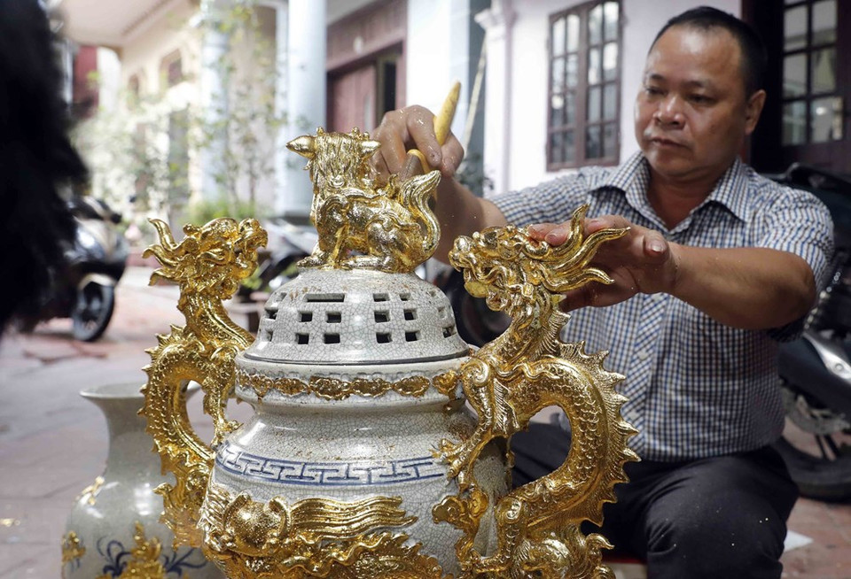 阮文钟艺人正在陶瓷作品上贴金箔。越通社记者 陈越 摄