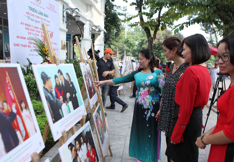 越南红十字会主席阮氏春秋和红十字会与红新月会国际联合会代表参观图片展。（图片来源：越通社）