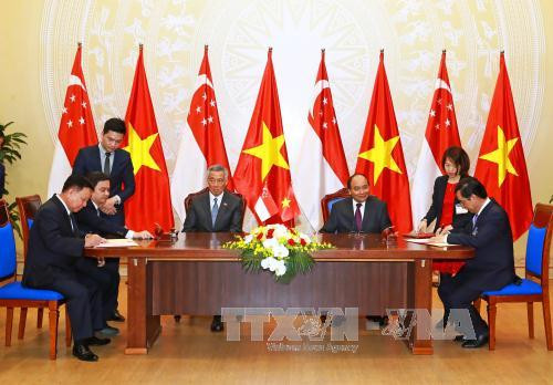 阮春福与李显龙见证广治省人民委员会与越南工业投资与越南工业投资发展有限责任公司（BECAMEX）和胜科工业集团之间的联营公司关于发展越新工业、城市和服务综合区（VSIP）的谅解备忘录签署仪式。（图片来源：越通社）