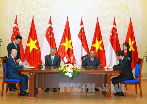 越南政府总理阮春福与新加坡总理李显龙见证越南工商部与新加坡胜科工业集团之间关于2号榕桔混合燃气轮机BOT项目谅解备忘录签署仪式。（图片来源：越通社）