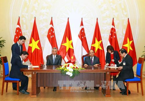 越南政府总理阮春福与新加坡总理李显龙见证岘港市人民委员会与胜科开发公司关于发展岘港市软件园谅解备忘录的签署仪式。（图片来源：越通社）