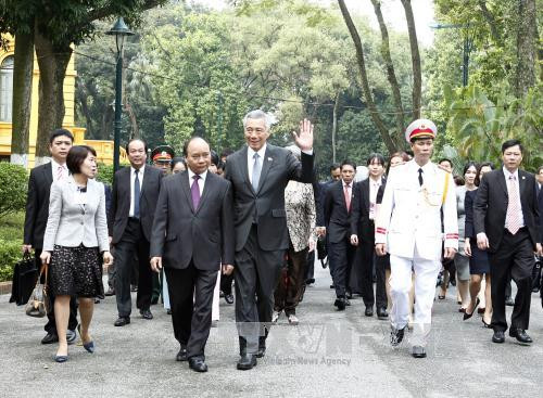 越南政府总理阮春福与新加坡总理李显龙前往政府总部进行会谈。（图片来源：越通社）